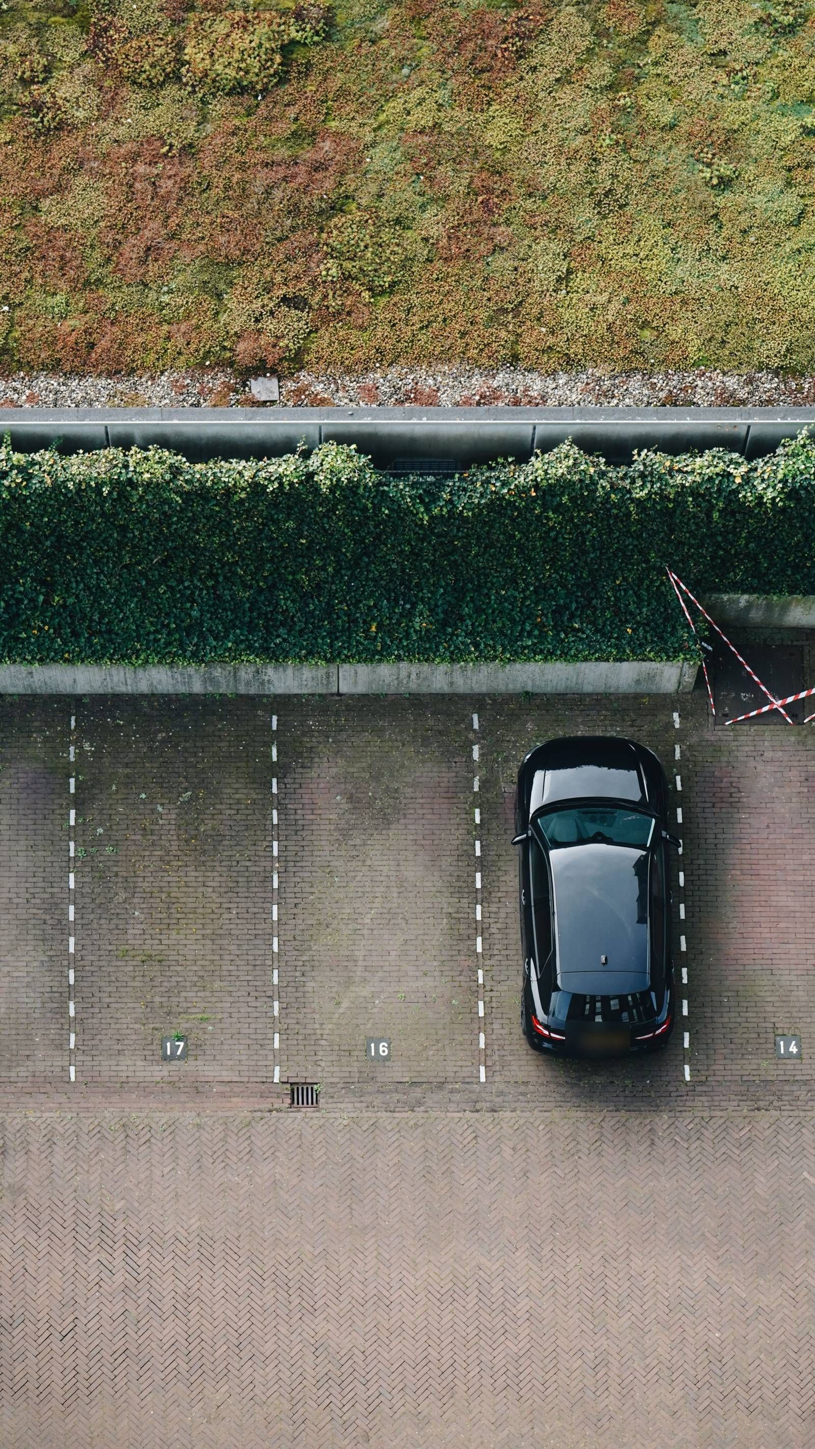 Genummerde parkeervakken met één geparkeerde auto, van bovenaf gezien